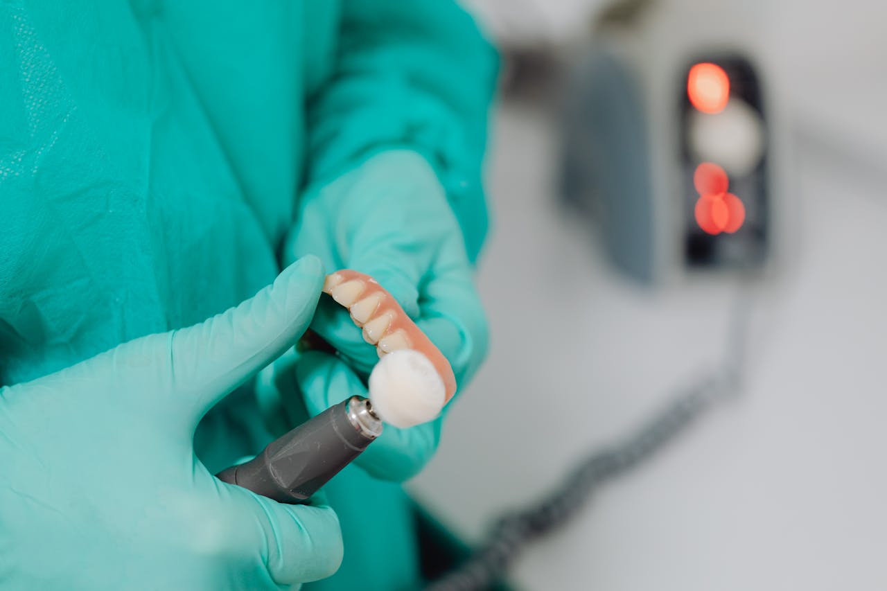 A close-up view of a dentist polishing a dental mold with precision. Ideal for dentistry or healthcare topics.